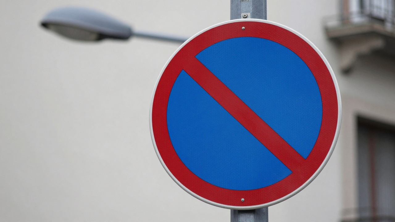 Close-up of a no stopping sign with red cross on blue background mounted on a lamp post along a city street